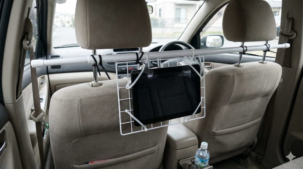 100均の突っ張り棒を運転席と助手席の間に渡し、そこにタブレットが結束バンドで留められている、自作のタブレット車載ホルダーの後部座席のイメージ